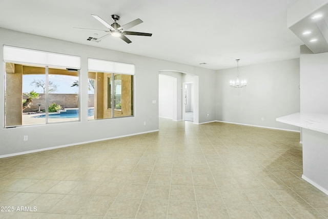 unfurnished room with ceiling fan with notable chandelier