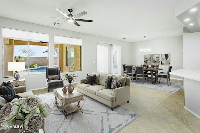 living room featuring light tile patterned floors and ceiling fan with notable chandelier