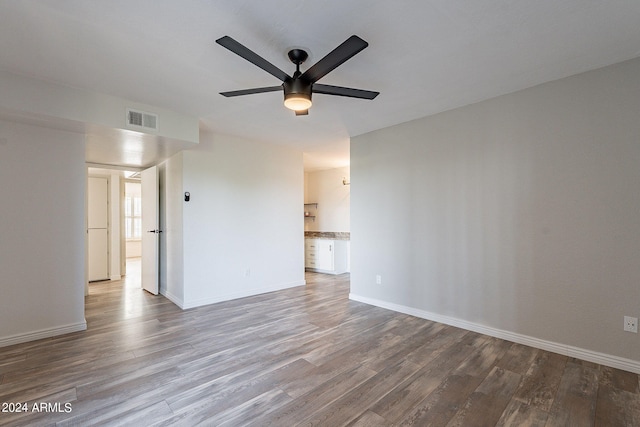 empty room featuring ceiling fan and hardwood / wood-style floors