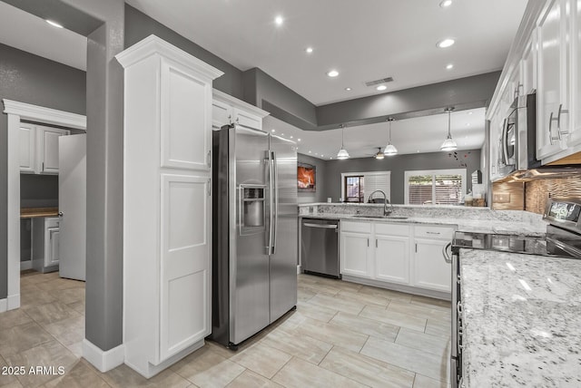 kitchen featuring white cabinetry, a peninsula, a sink, and stainless steel appliances