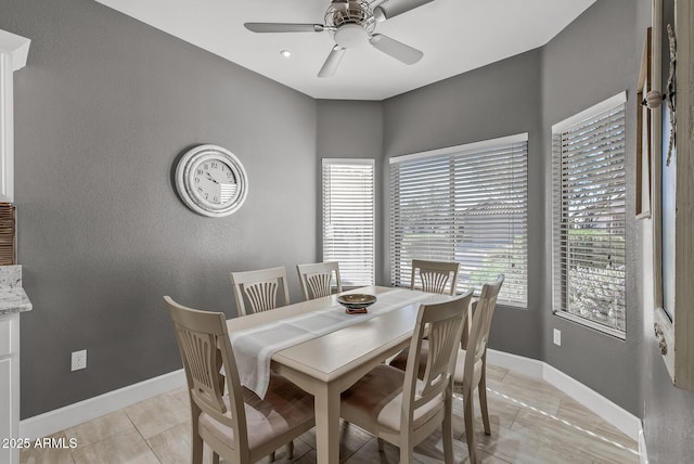 dining room with light tile patterned floors, baseboards, and ceiling fan