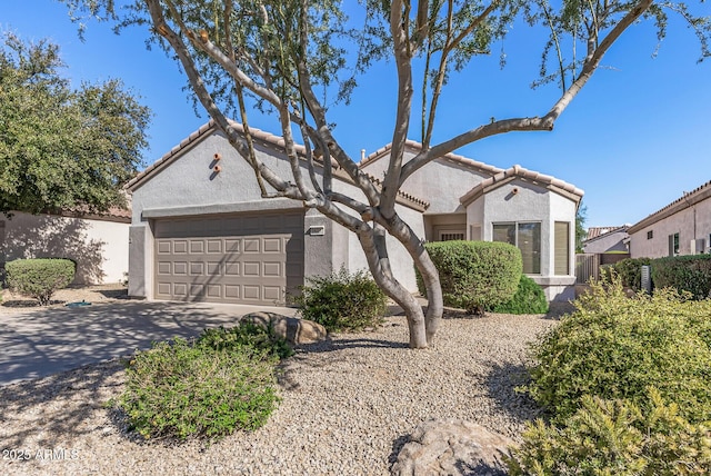 mediterranean / spanish-style house featuring a garage, fence, driveway, and stucco siding