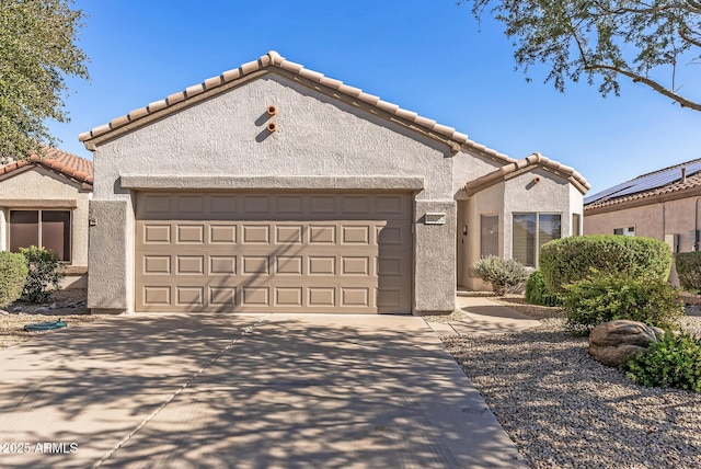 mediterranean / spanish home with stucco siding, a garage, driveway, and a tiled roof