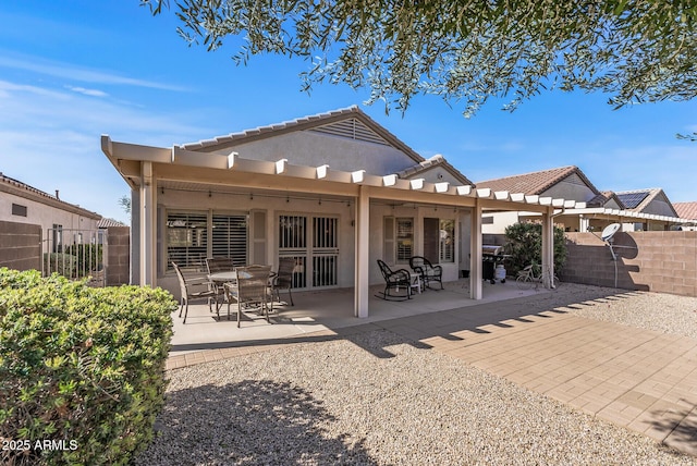 back of property featuring a tiled roof, a patio area, stucco siding, and fence