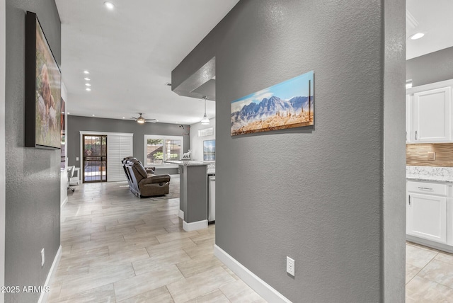 corridor with recessed lighting, baseboards, and a textured wall