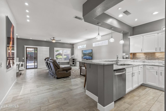 kitchen with visible vents, a peninsula, white cabinets, stainless steel dishwasher, and open floor plan