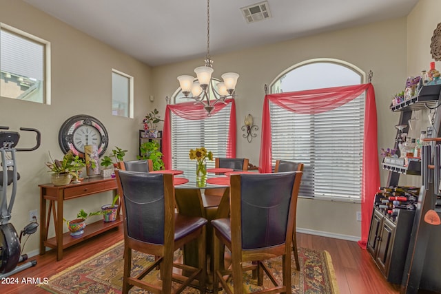 dining area featuring wood-type flooring and a chandelier