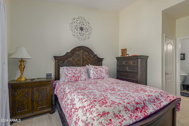 bedroom featuring light carpet and ensuite bathroom