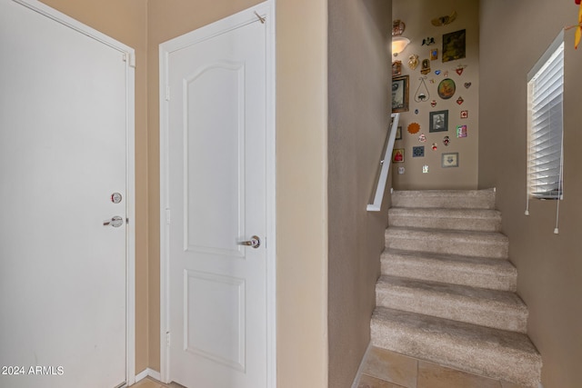 stairs featuring tile patterned flooring