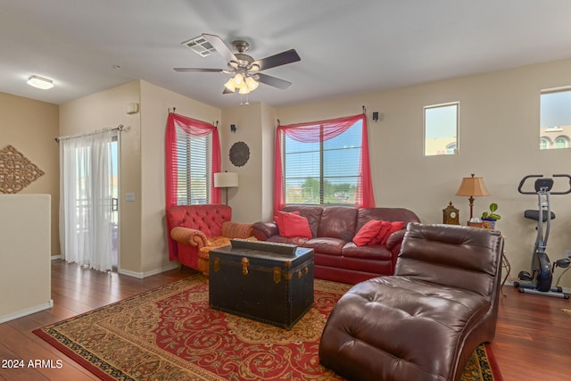 living room featuring dark wood-type flooring and ceiling fan