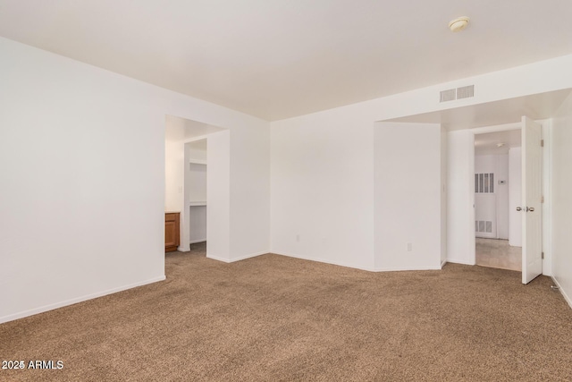 carpeted empty room with a smoke detector and baseboards