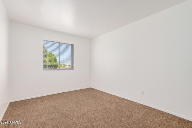 spare room with carpet and baseboards