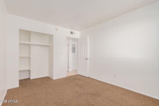 unfurnished bedroom featuring carpet, a closet, baseboards, and electric panel