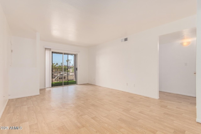 empty room with light wood finished floors and baseboards