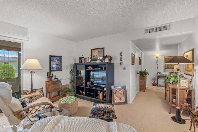 living room with visible vents, a textured ceiling, and light colored carpet