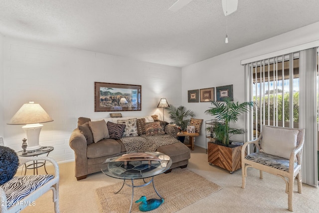 living room with a textured ceiling, a ceiling fan, and light colored carpet
