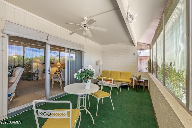 sunroom / solarium featuring a ceiling fan and beamed ceiling