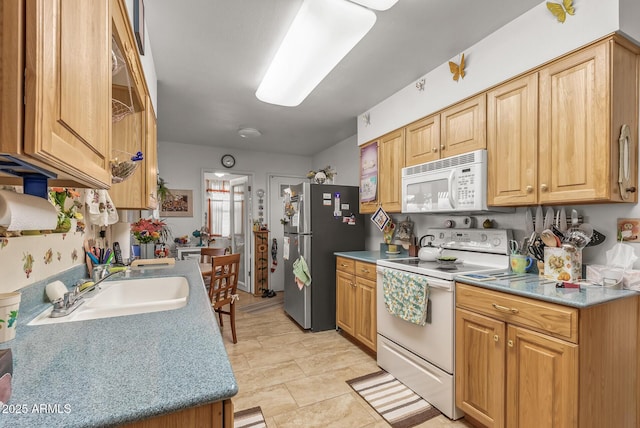 kitchen with white appliances, light countertops, and a sink