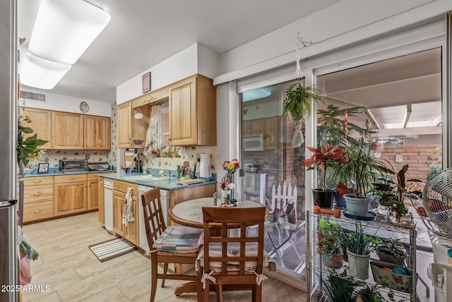 kitchen with light countertops, tasteful backsplash, a sink, and a toaster
