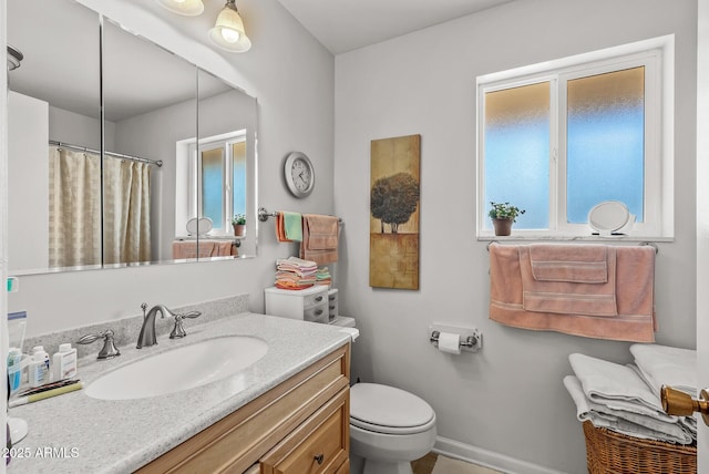full bath featuring baseboards, vanity, and toilet