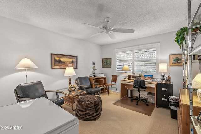 office featuring light carpet, ceiling fan, and a textured ceiling