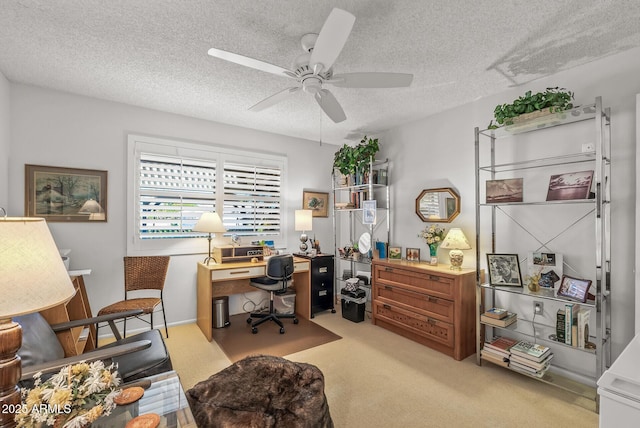 office featuring light carpet, a ceiling fan, and a textured ceiling