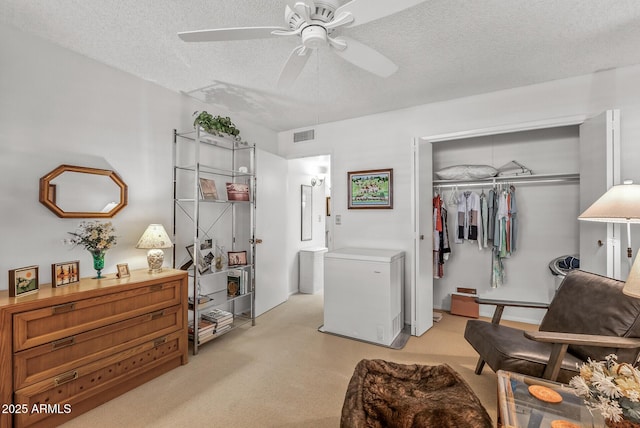living area with a ceiling fan and a textured ceiling