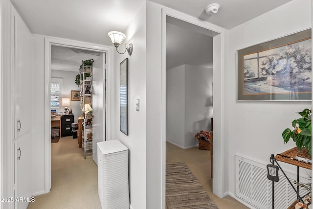 hallway featuring visible vents and light colored carpet