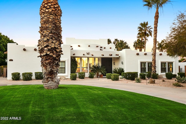 view of front of house featuring a front lawn and stucco siding