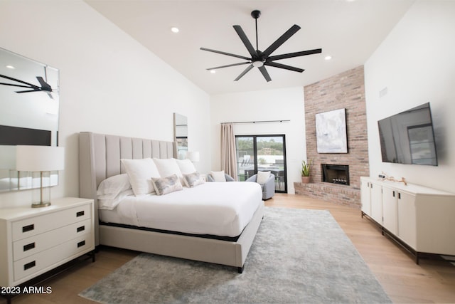 bedroom with a large fireplace, light wood-type flooring, access to exterior, and recessed lighting