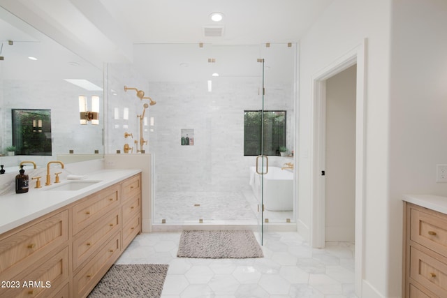 full bath with tiled shower, a freestanding bath, and vanity