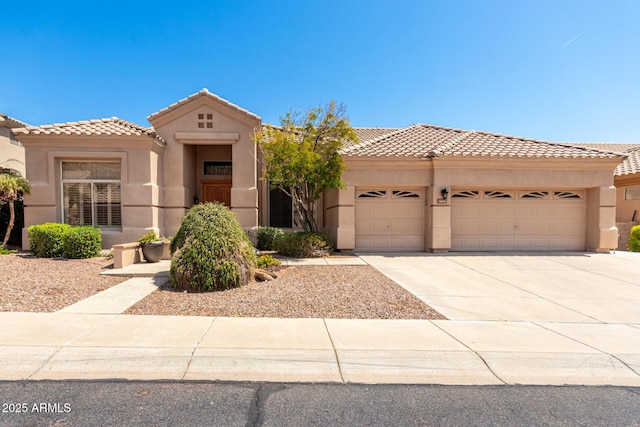 view of front facade featuring an attached garage, driveway, stucco siding, and a tile roof