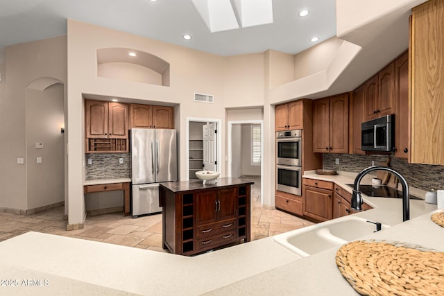 kitchen featuring a sink, visible vents, stone tile flooring, and stainless steel appliances