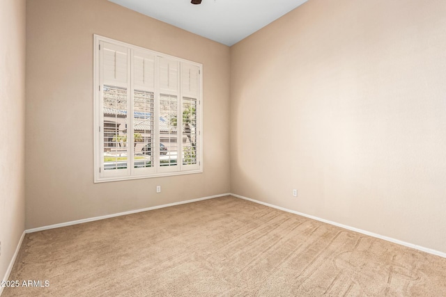 spare room featuring carpet and baseboards
