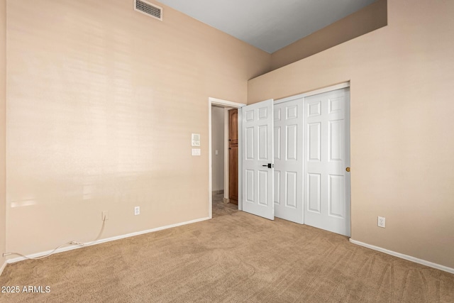 unfurnished bedroom featuring visible vents, baseboards, a closet, and carpet floors