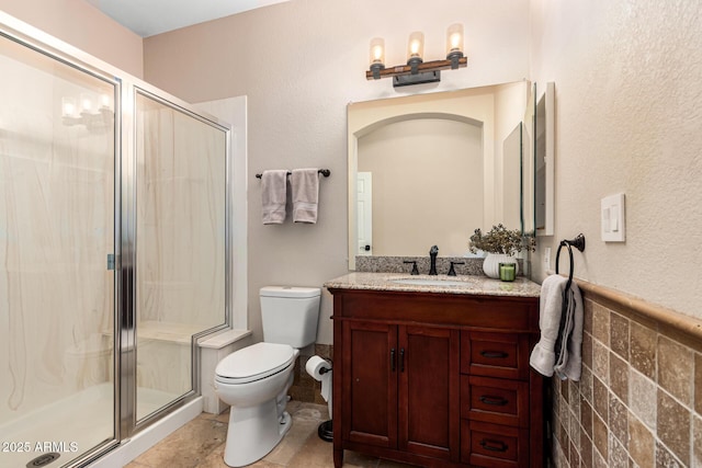 bathroom with toilet, a stall shower, and vanity