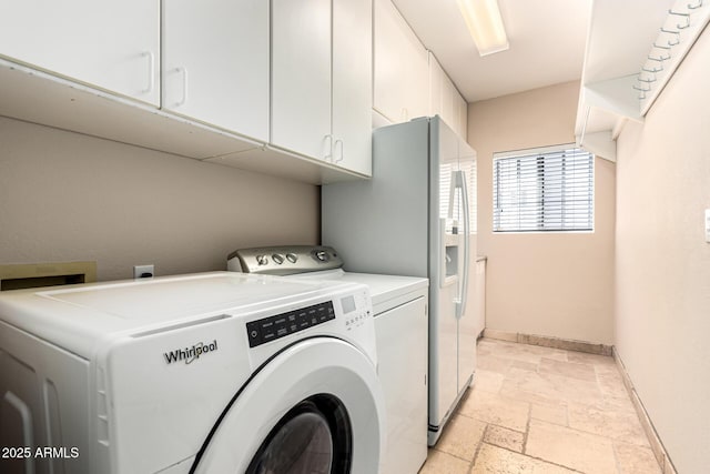 laundry room featuring independent washer and dryer, stone tile floors, baseboards, and cabinet space