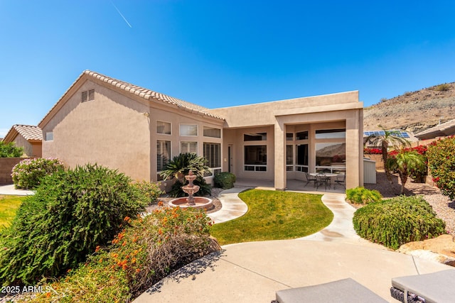 rear view of property featuring a patio and stucco siding