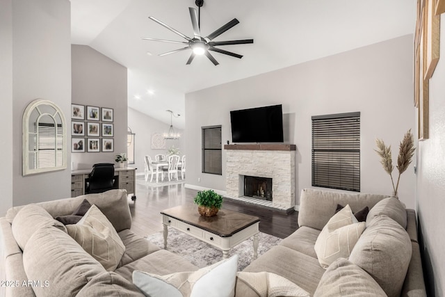 living room featuring high vaulted ceiling, a fireplace, wood finished floors, a ceiling fan, and baseboards