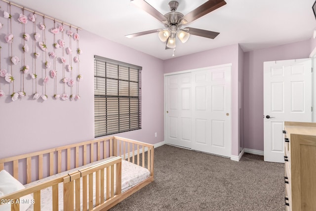 unfurnished bedroom featuring a crib, a closet, baseboards, and carpet flooring