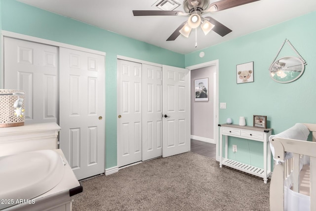 bedroom with baseboards, visible vents, ceiling fan, carpet, and multiple closets