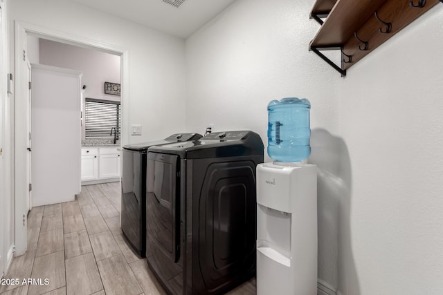 clothes washing area with washer and dryer, laundry area, and wood tiled floor