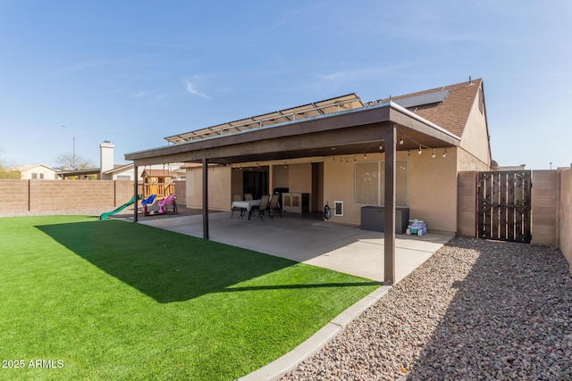 rear view of house with a patio, a yard, a fenced backyard, and stucco siding