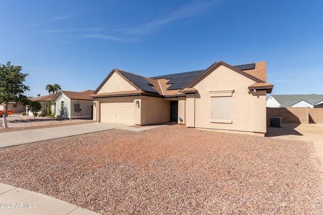 ranch-style home with a garage, concrete driveway, fence, central AC, and stucco siding