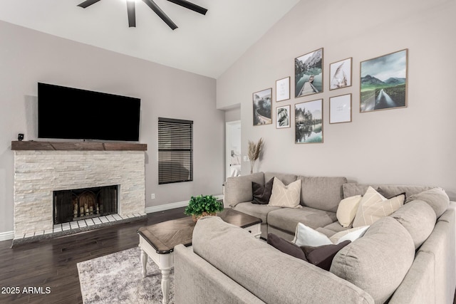 living area with dark wood-type flooring, a fireplace, baseboards, and a ceiling fan