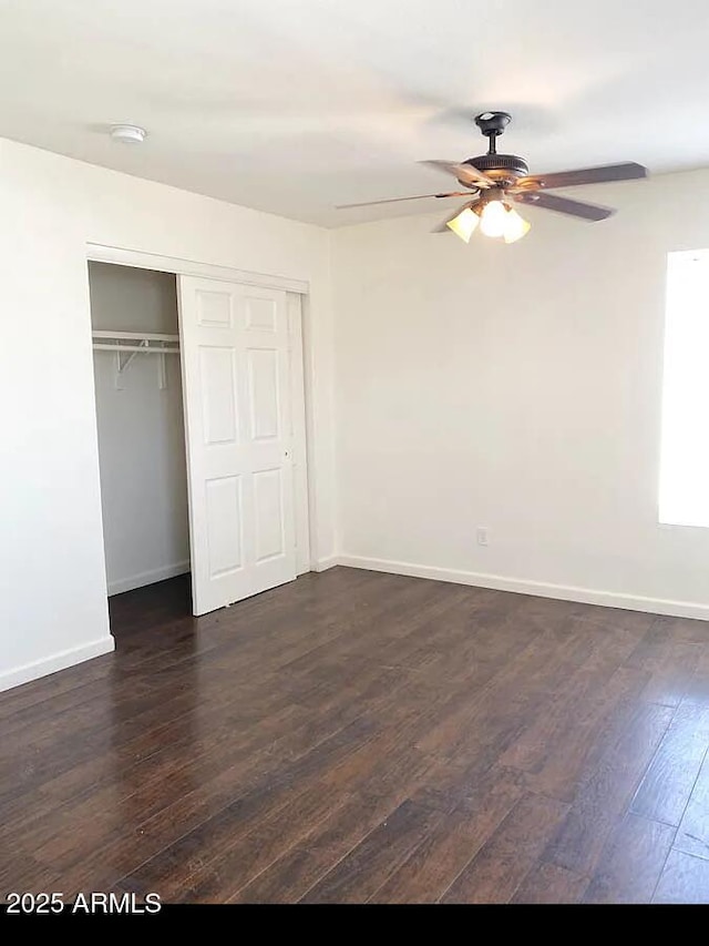 unfurnished bedroom featuring dark wood-type flooring, a closet, and ceiling fan