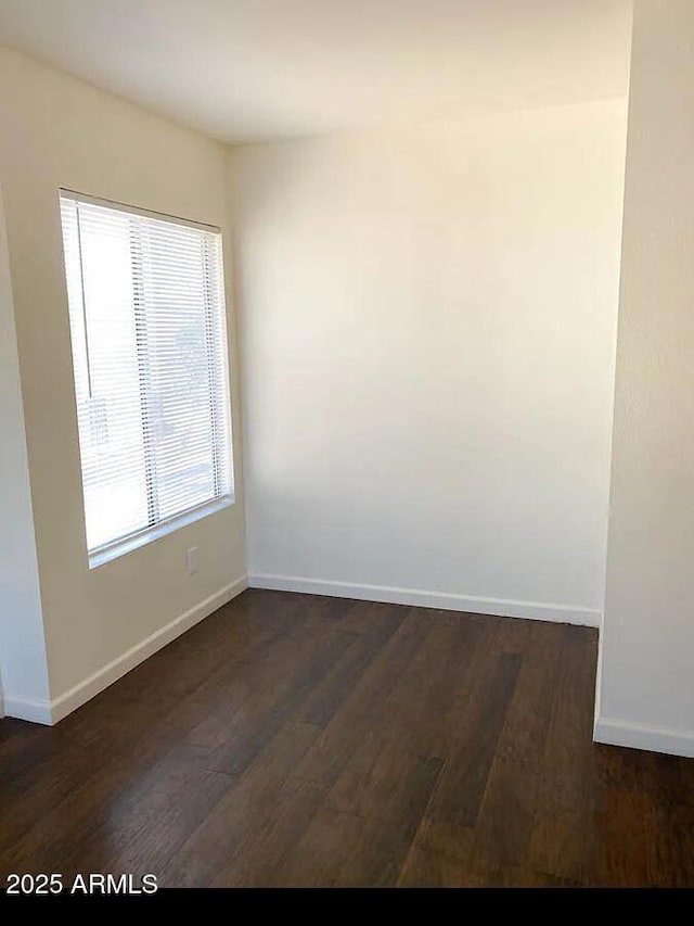 unfurnished room with dark hardwood / wood-style flooring