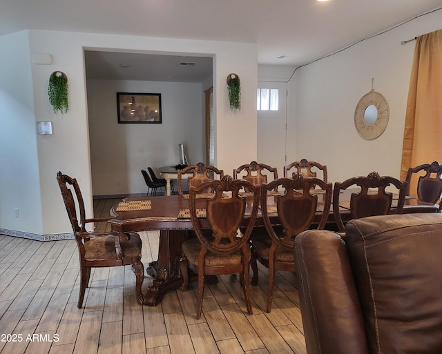 dining space with light wood-style floors and baseboards