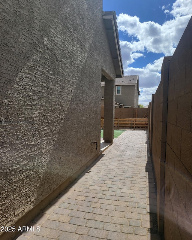 view of property exterior with a patio and fence