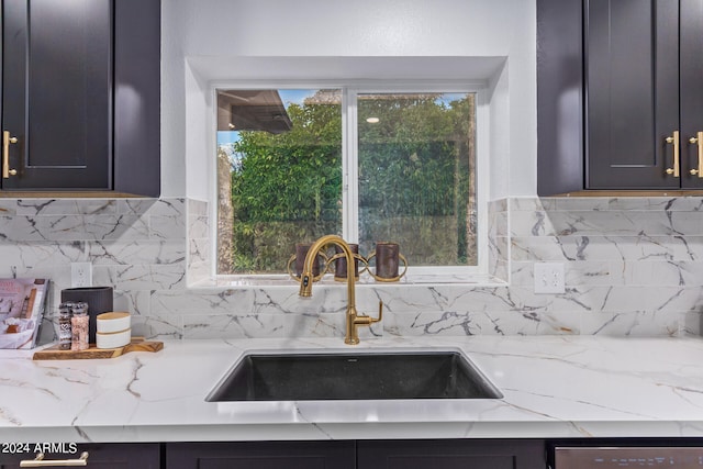 kitchen featuring dishwasher, tasteful backsplash, sink, and light stone countertops